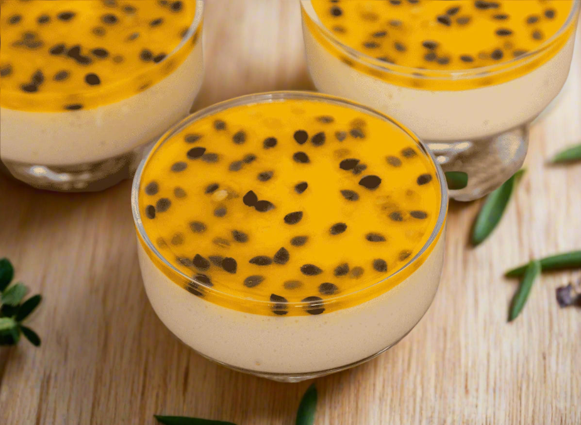 Three dessert cups with a white base, yellow topping, and black seeds on a textured surface.
