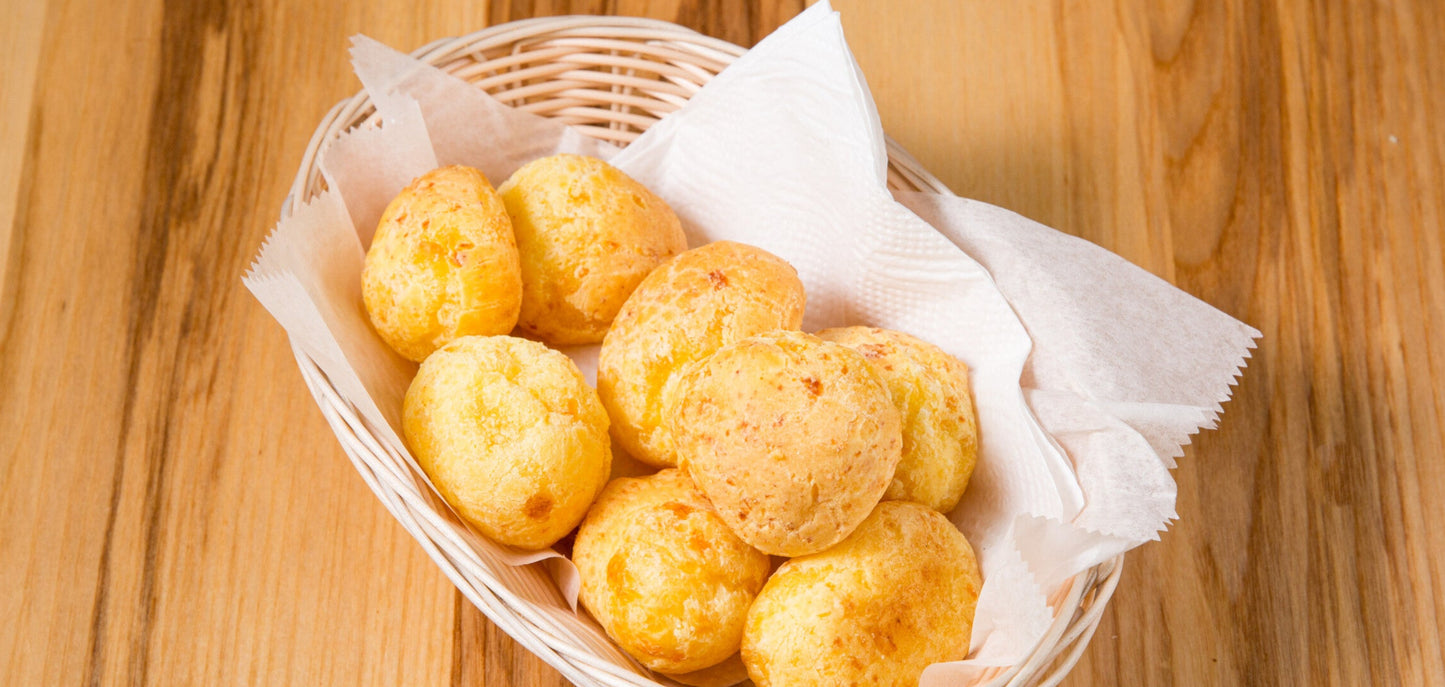 Basket of cheese bread rolls on a wooden table
